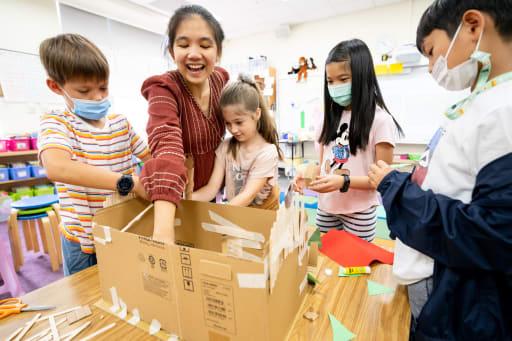 Elementary school teacher guiding students through a hands-on engineering design challenge in the classroom