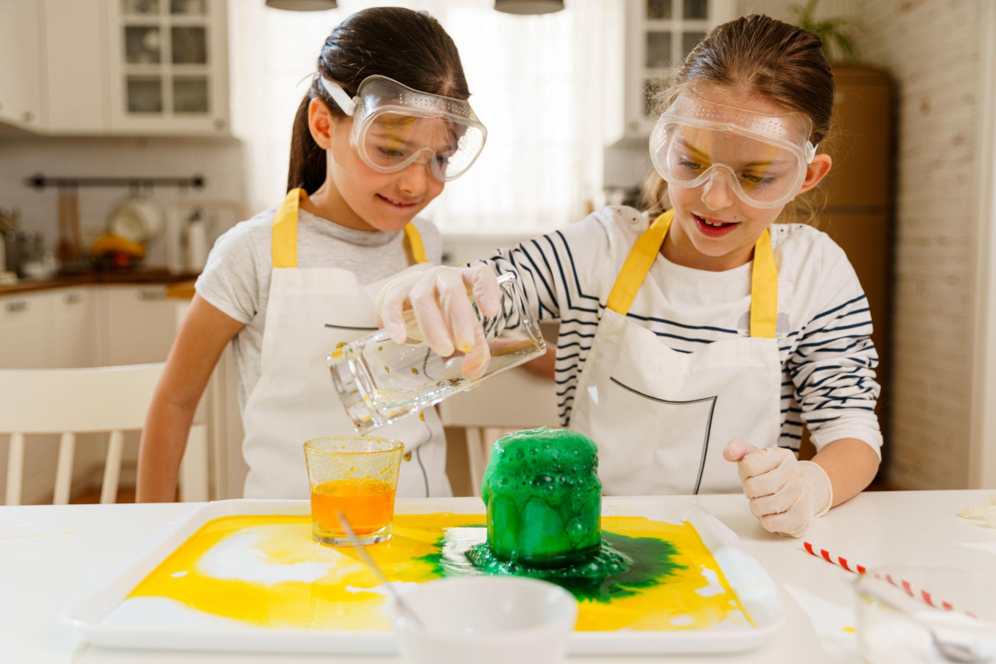 Children doing hands-on STEM activities with everyday household materials at a kitchen table
