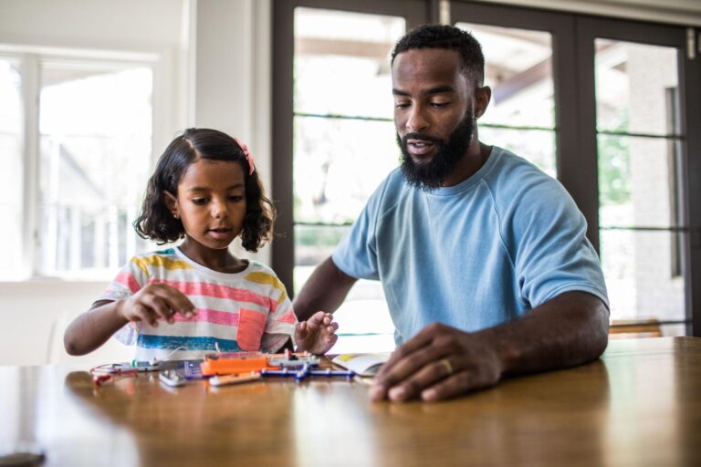 Parent helping a child discover STEM career interests through a hands-on engineering activity